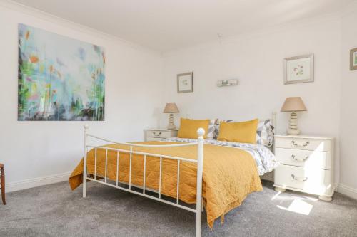 a bedroom with a bed and a painting on the wall at Manege Cottage in Chacewater