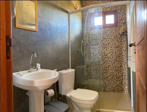 a bathroom with a toilet and a sink and a shower at Casa Vale do Sol in Serra de São Bento