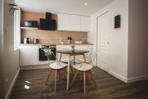 une cuisine avec une table et des chaises dans une pièce dans l'établissement La Cachette Rouge, à Saint-Valery-sur-Somme