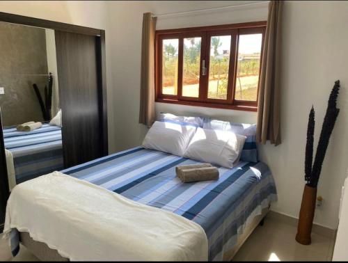a bedroom with a bed with a blue and white bedspread at Casa Vale do Sol in Serra de São Bento