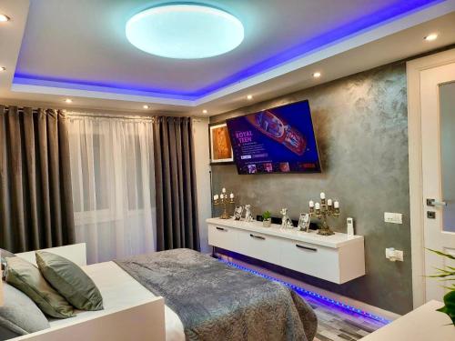 um quarto com uma cama e uma televisão na parede em Studio DeLux em Giurgiu