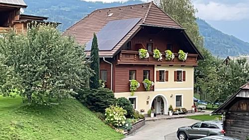 dom z samochodem zaparkowanym przed nim w obiekcie Gästehaus Biobauernhof Mandl w mieście Murau