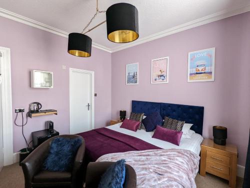 a bedroom with a large bed and a chair at Villa Marina in Torquay