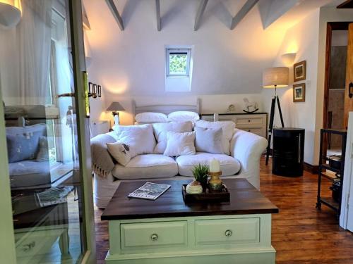 a living room with a white couch and a table at 'Halt Lodge' A Scandinavian Home in an AONB in Lydbrook