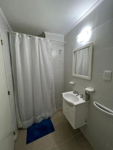 a bathroom with a white shower curtain and a sink at Departamento en zona centro in Resistencia