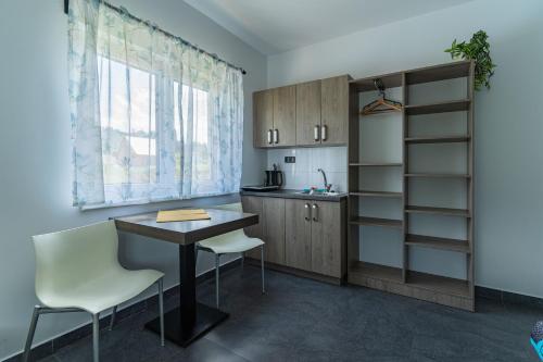 a kitchen with a table and chairs and a window at APARTMÁNY POD SJEZDOVKOU in Abertamy