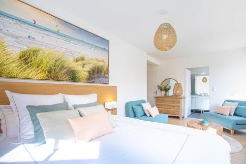 um quarto com uma cama branca e um sofá azul em La Clé de Quentovic ◎ Duplex de 150 m2 ◎ Standing em Le Touquet-Paris-Plage