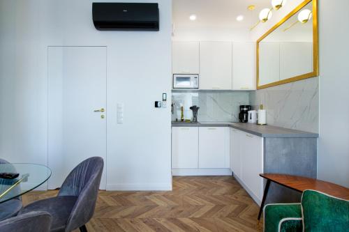 a kitchen with white cabinets and a table and chairs at Apartamenty Olimpijska by RENT4YOU in Olsztyn