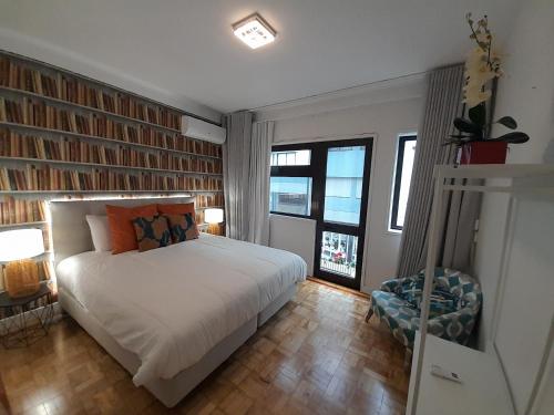 Schlafzimmer mit einem Bett, einem Stuhl und Fenstern in der Unterkunft Cozy Central 3 Bedrooms Bragas in Porto