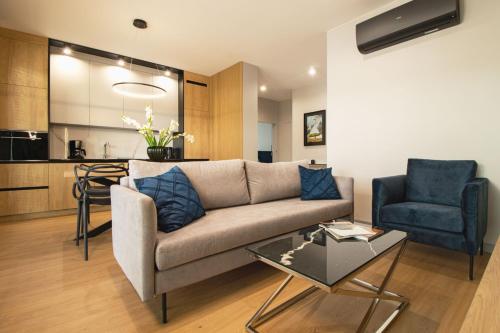 a living room with a couch and a chair at Apartamenty Olimpijska by RENT4YOU in Olsztyn