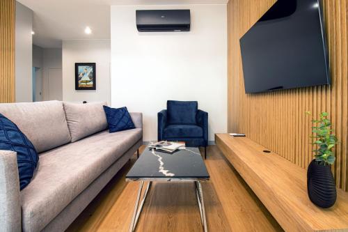 a living room with a couch and a tv at Apartamenty Olimpijska by RENT4YOU in Olsztyn