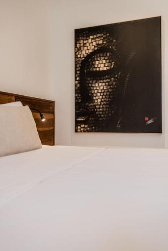 a bedroom with a bed and a painting on the wall at Triângulo Noronha in Fernando de Noronha