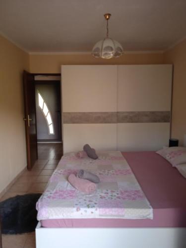 a bedroom with a pink bed with shoes on it at Apartment D&J in Mošćenička Draga