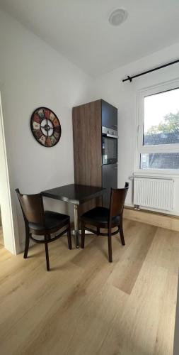 a dining room with a table and chairs and a clock at My Apartment im Bremer Viertel in Bremen