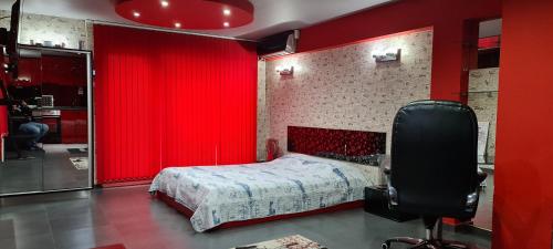 a bedroom with red curtains and a bed with a chair at Casa De Cristal in Sofia