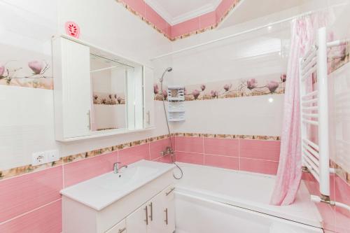 a pink bathroom with a sink and a mirror at Apartament spatios in complex residential in Chişinău