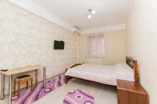 a bedroom with a bed and a desk and a tv at Apartament spatios in complex residential in Chişinău
