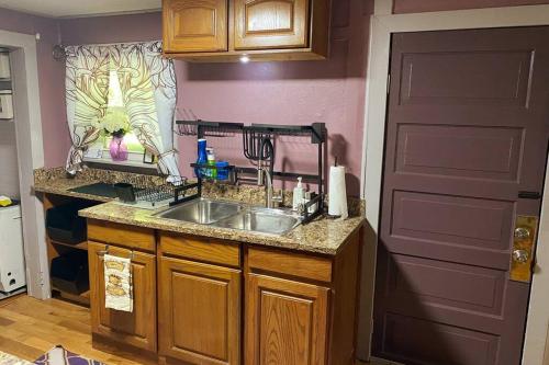 a kitchen with a sink and a counter and a door at Plum Crooked Poets Cottage - Walk to Town - Luxury King Bed - Near Asheville - Excellent Wi-Fi in Marshall