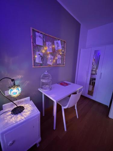 a purple room with a table and a bird cage at MalaMù BnB Eventi in Rigosa