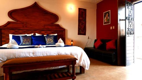 a bedroom with a large bed with blue and red walls at Ganesha Hotel in San Cristóbal de Las Casas