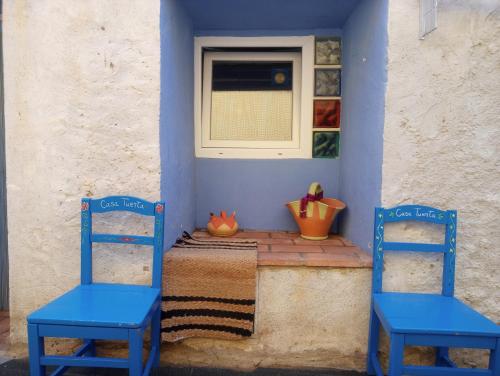 Dos sillas azules sentadas en una mesa en una habitación en Casa Tuerta, en Alcalá de Moncayo