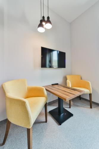 a room with two chairs and a table and a tv at Hotel Vladimir in Budva