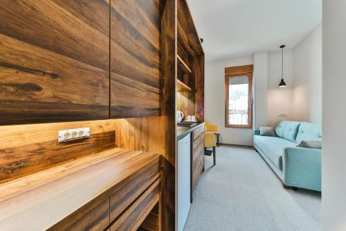 a kitchen with wooden cabinets and a living room at Hotel Vladimir in Budva