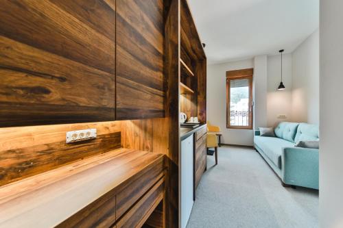 a kitchen with wooden cabinets and a living room at Hotel Vladimir in Budva