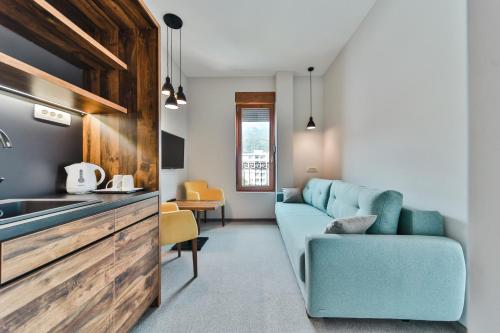 a living room with a blue couch and a kitchen at Hotel Vladimir in Budva