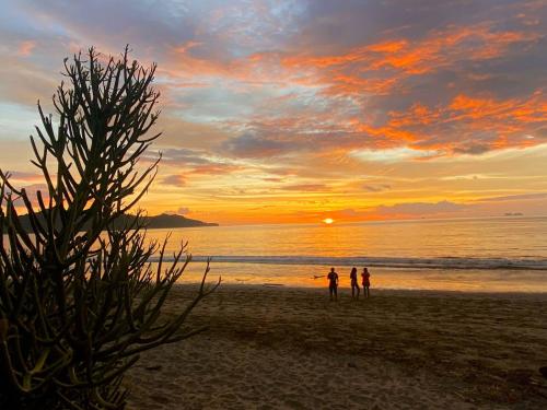 two people standing on the beach at sunset at Hotel Brasilito in Brasilito