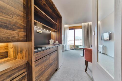 a kitchen with wooden cabinets and a sink in a room at Hotel Vladimir in Budva