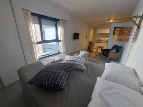 - un salon avec un lit et des oreillers dans l'établissement Alquiler Temporario Rosario 3, à Rosario