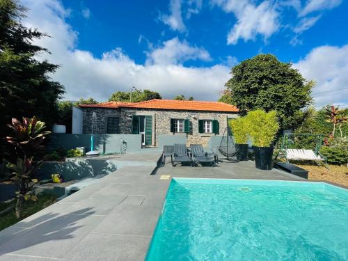 a villa with a swimming pool in front of a house at The Farm House.23 in Funchal