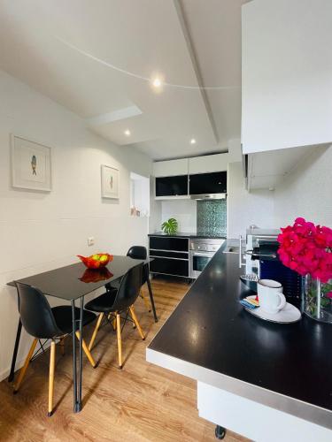 a kitchen with a black table and black chairs at The Farm House.23 in Funchal