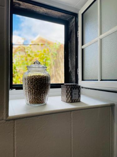 a vase sitting on a window sill in front of a window at The Farm House.23 in Funchal