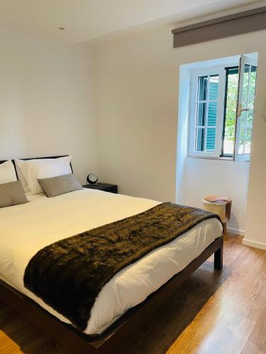 a bedroom with a large bed with a window at The Farm House.23 in Funchal