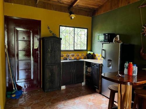 a kitchen with a refrigerator and a table in it at Casa vacacional Brisas del Mar in San Juanillo