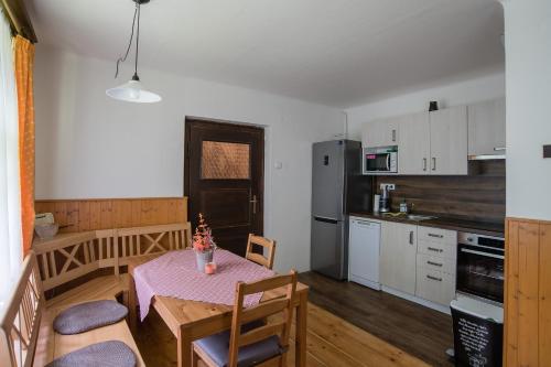 a kitchen and dining room with a table and chairs at Chalupa Herman in Rudník