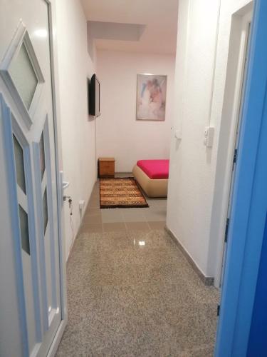 a hallway with a room with a bed and a door at Sphinx Apartment in Visoko