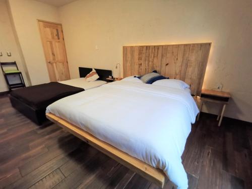 Schlafzimmer mit einem großen Bett mit einem Kopfteil aus Holz in der Unterkunft Hotel Casa Acueducto - Lujo Cultural in Oaxaca de Juárez