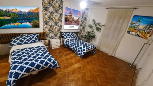 Habitación con 2 camas y pinturas en la pared. en SOL- CARLOS V Apartaments, en Madrid