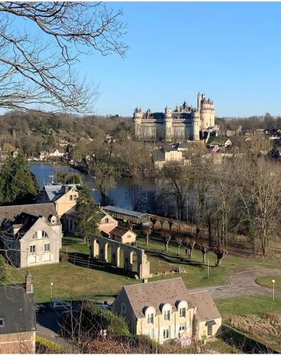 a castle on a hill with houses and a lake at 5 pièces familiales in Trosly-Breuil