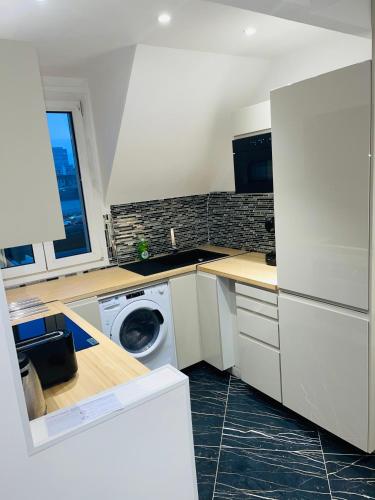 une cuisine avec un lave-linge et un lave-linge dans l'établissement APPARTEMENT AVEC VUE SUR LA TOUR EIIFEL, à Issy-les-Moulineaux