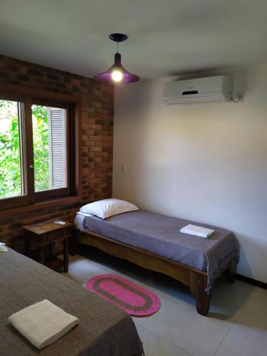 a bedroom with two beds and a window at Amanita Rosa in Praia do Rosa