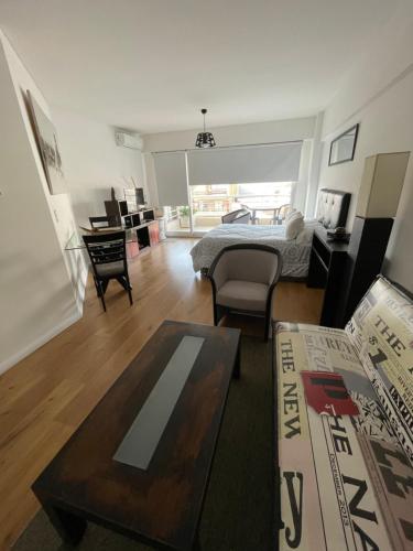 une chambre avec un lit et un salon avec une table dans l'établissement libertador 6040, à Buenos Aires