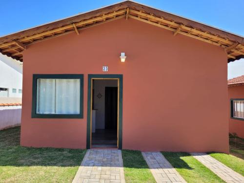 ein kleines Haus mit orangefarbener Wand in der Unterkunft San Nicolas Residêncial in São Bento do Sapucaí