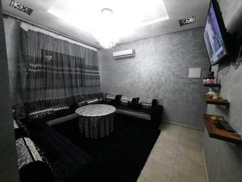 een woonkamer met een bank en een tafel bij اقامة البحتوري in Nador