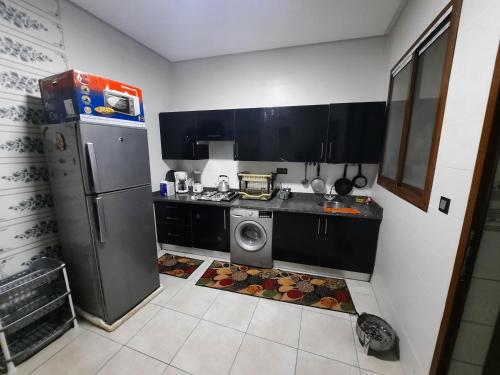 een keuken met een koelkast en een wasmachine bij اقامة البحتوري in Nador