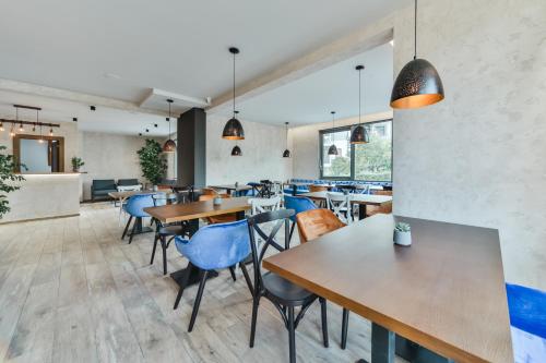 a restaurant with wooden tables and blue chairs at Hotel Vladimir in Budva
