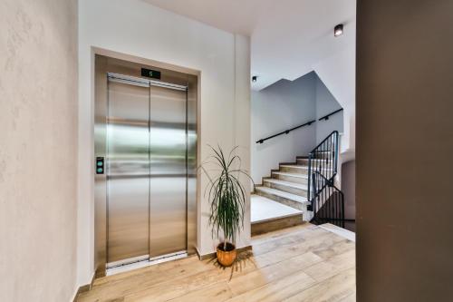 a hallway with a glass elevator and a potted plant at Hotel Vladimir in Budva